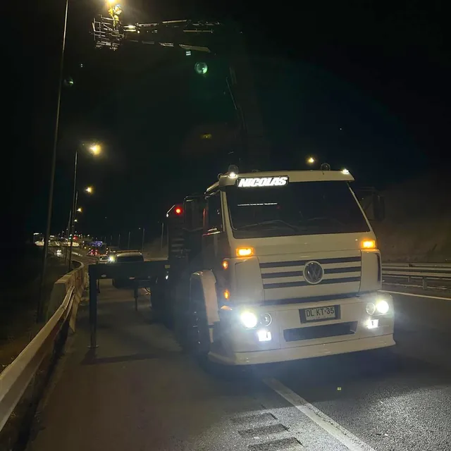 Camión de NCS Crane trabajando de noche en una autopista